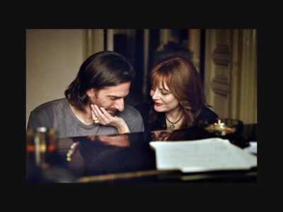Fotografía de The Echo Chamber: dos personajes junto a un piano.