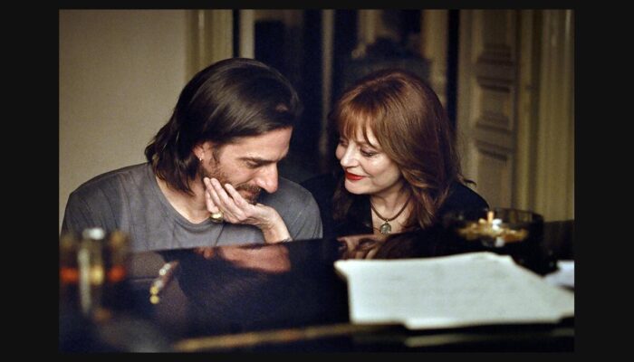 Fotografía de The Echo Chamber: dos personajes junto a un piano.
