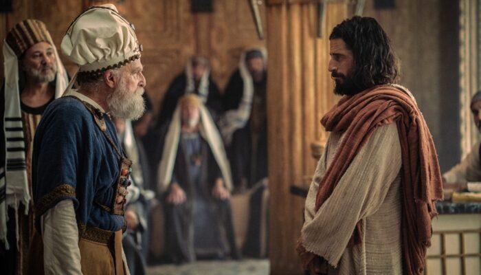 Jonathan Roumie como Jesús frente a una autoridad religiosa en The Chosen T6.
