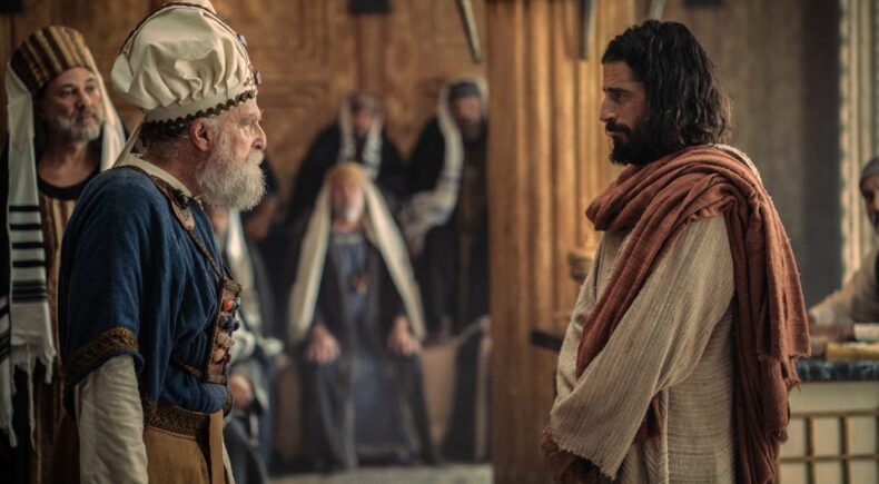 Jonathan Roumie como Jesús frente a una autoridad religiosa en The Chosen T6.